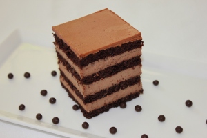 The cake is a super moist dark rich chocolate sponge cake, filled with a delicately light yet insanely creamy chocolate pastry cream, and draped with an icing of chocolate buttercream that just melts in your mouth. 